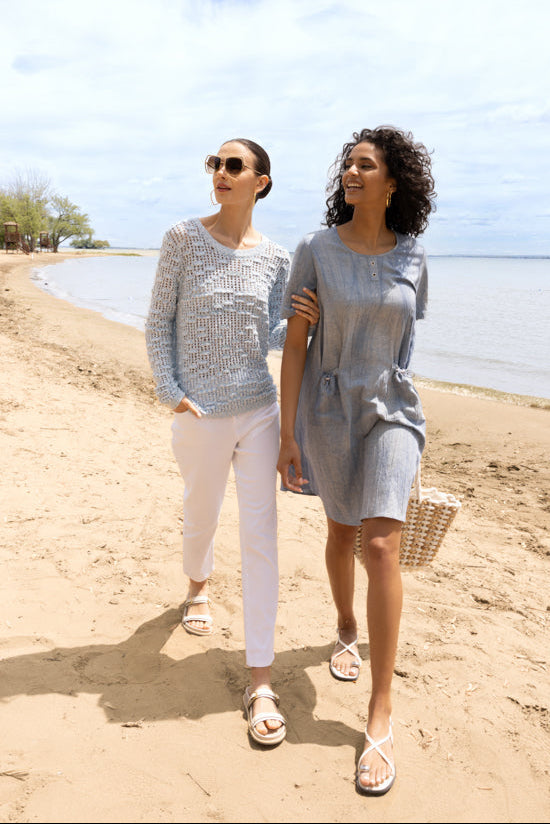 Images show the Alison Sheri Relaxed Pocket Dress A47072 in Sand and Indigo from the front and side, highlighting the round neckline, relaxed fit, elbow-length sleeves, side pockets with gentle cinching effect, and the fluid drape of the lightweight linen-blend fabric.