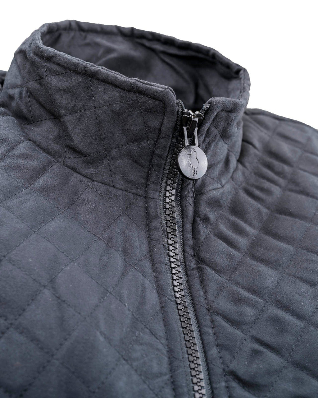 Women’s Grand Prix Vest by Outback Trading Co. in black, highlighting the quilted microsuede fabric, 2-way zipper closure, zippered pockets, adjustable back tabs, and drop-tail hem. Photos provide front, back, and close-up views emphasizing texture, fit, and craftsmanship.