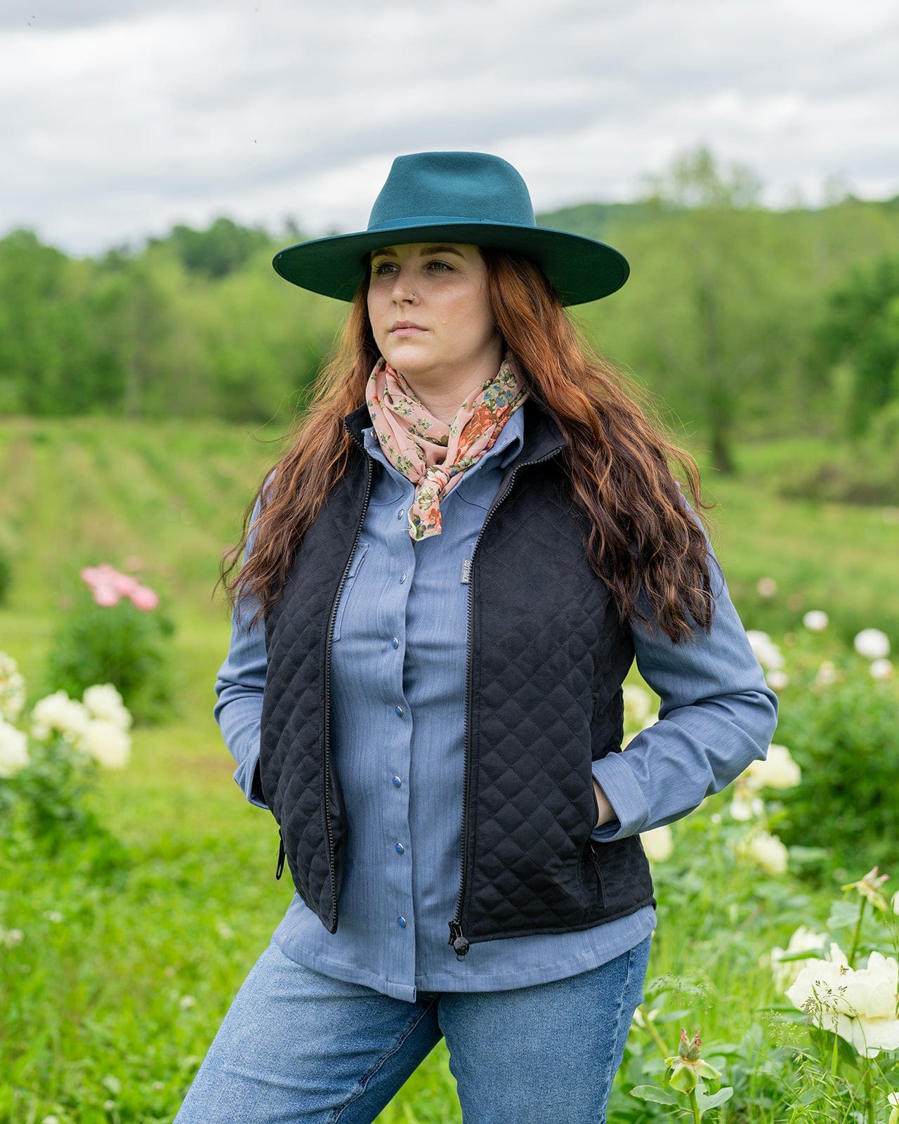 Women’s Grand Prix Vest by Outback Trading Co. in black, highlighting the quilted microsuede fabric, 2-way zipper closure, zippered pockets, adjustable back tabs, and drop-tail hem. Photos provide front, back, and close-up views emphasizing texture, fit, and craftsmanship.