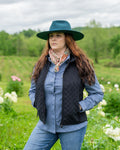 Women’s Grand Prix Vest by Outback Trading Co. in black, highlighting the quilted microsuede fabric, 2-way zipper closure, zippered pockets, adjustable back tabs, and drop-tail hem. Photos provide front, back, and close-up views emphasizing texture, fit, and craftsmanship.